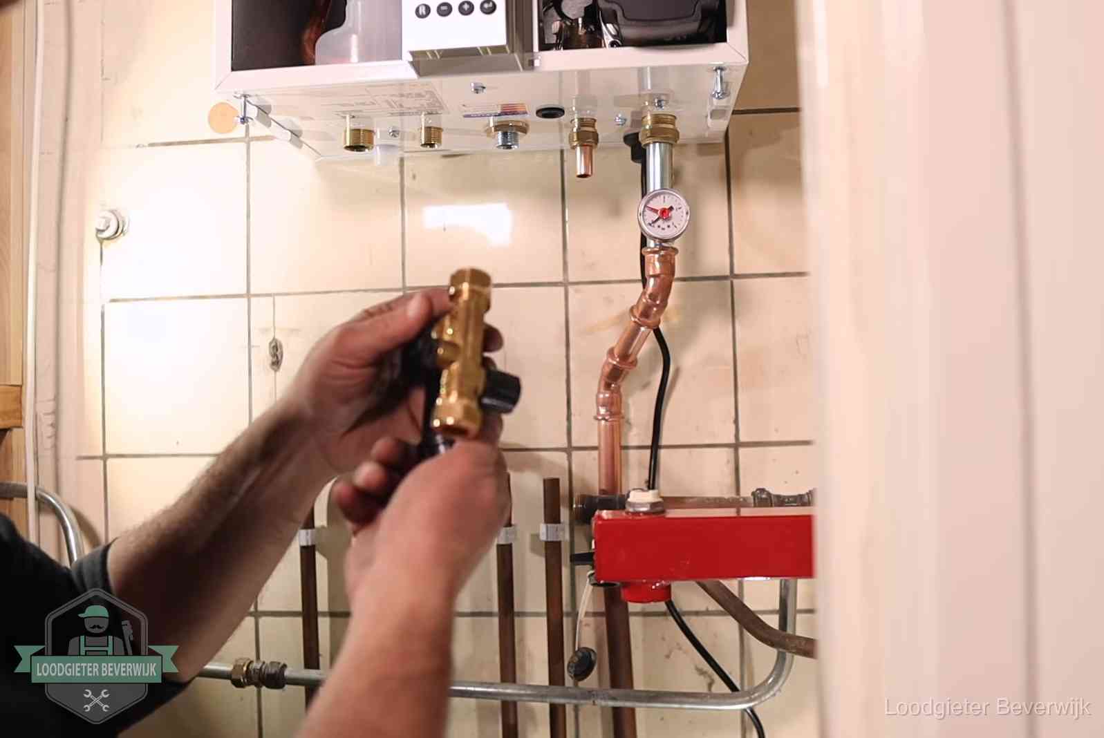 Vulkraan en manometer onder een cv-ketel voor het bijvullen van de waterdruk in Beverwijk