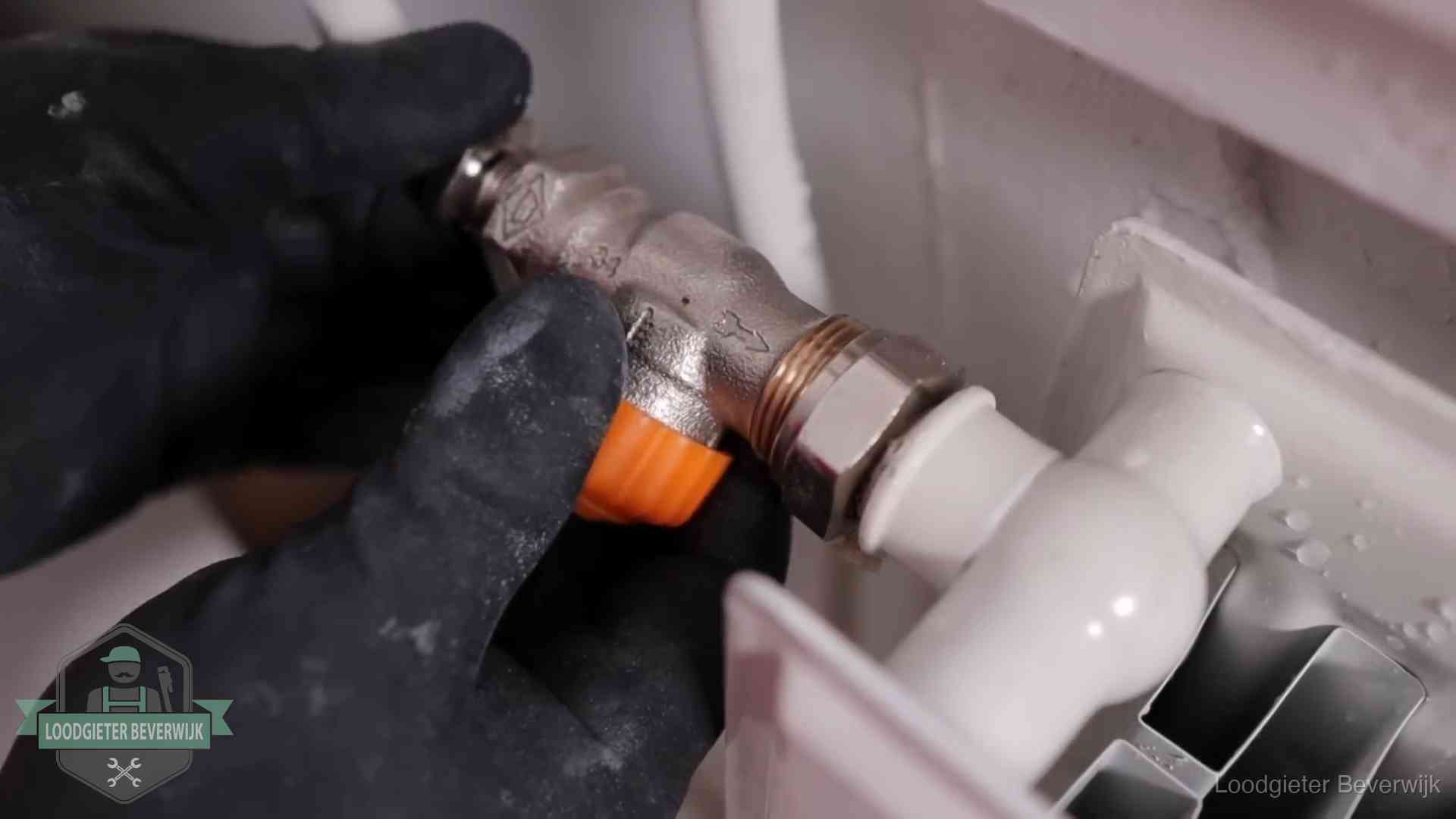 Thermostaatkraan wordt gemonteerd op een radiator in Beverwijk voor het stookseizoen