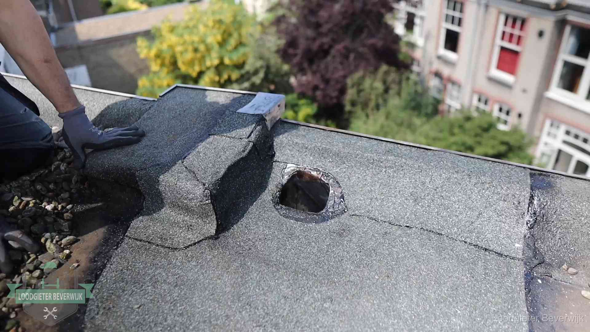 Daklekkage-inspectie op een plat dak in Beverwijk Loodgieter inspecteert een beschadigd bitumen plat dak tijdens een daklekkage-inspectie in Beverwijk
