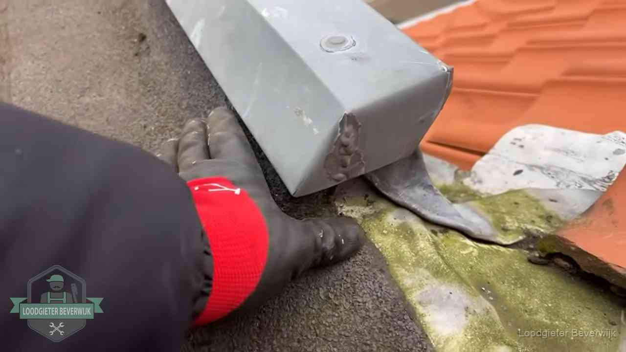 Hemelwaterafvoer en dakgoot controleren in Beverwijk Controle van een zinken hemelwaterafvoer met loodslab bij dakpannen in Beverwijk