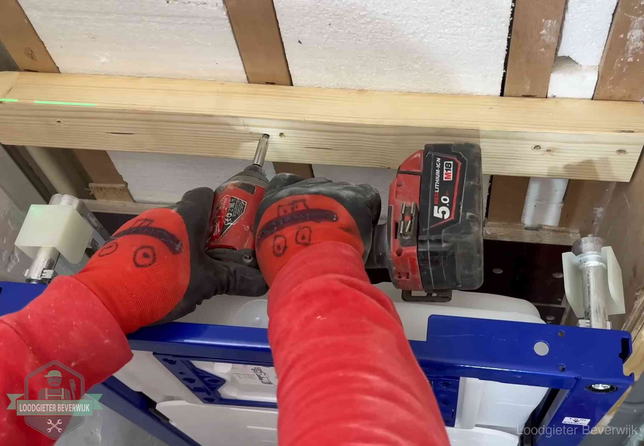 Monteur bevestigt een inbouwreservoir voor een hangend toilet in Beverwijk