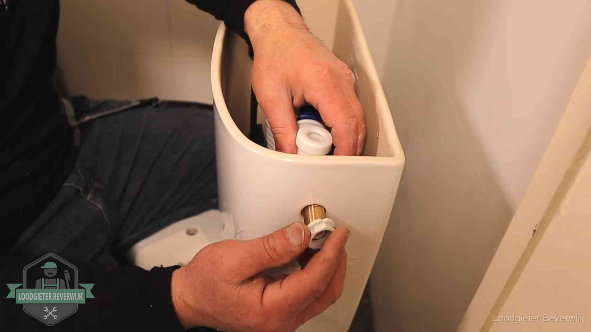 Loodgieter monteert de vlotterkraan van een stortbak bij een toilet in Beverwijk