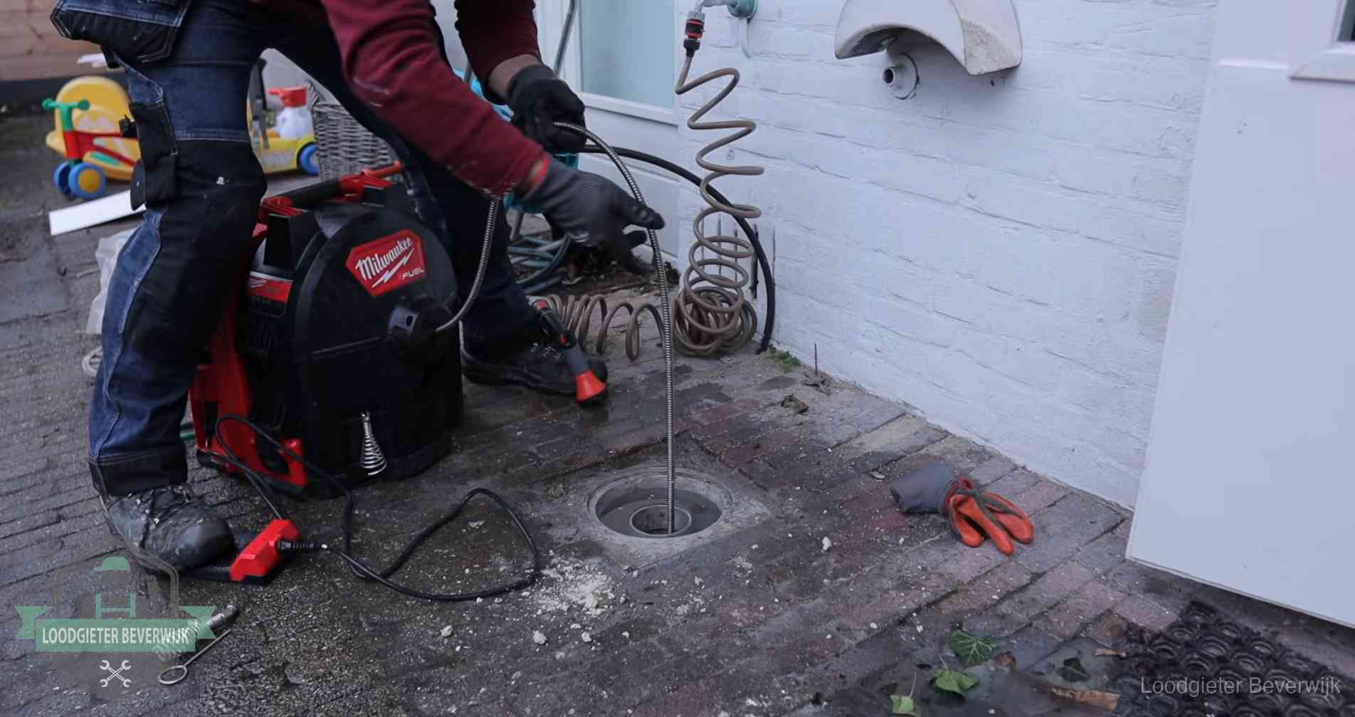 Ontstoppingsputje in de bestrating naast de gevel van een woning in Beverwijk