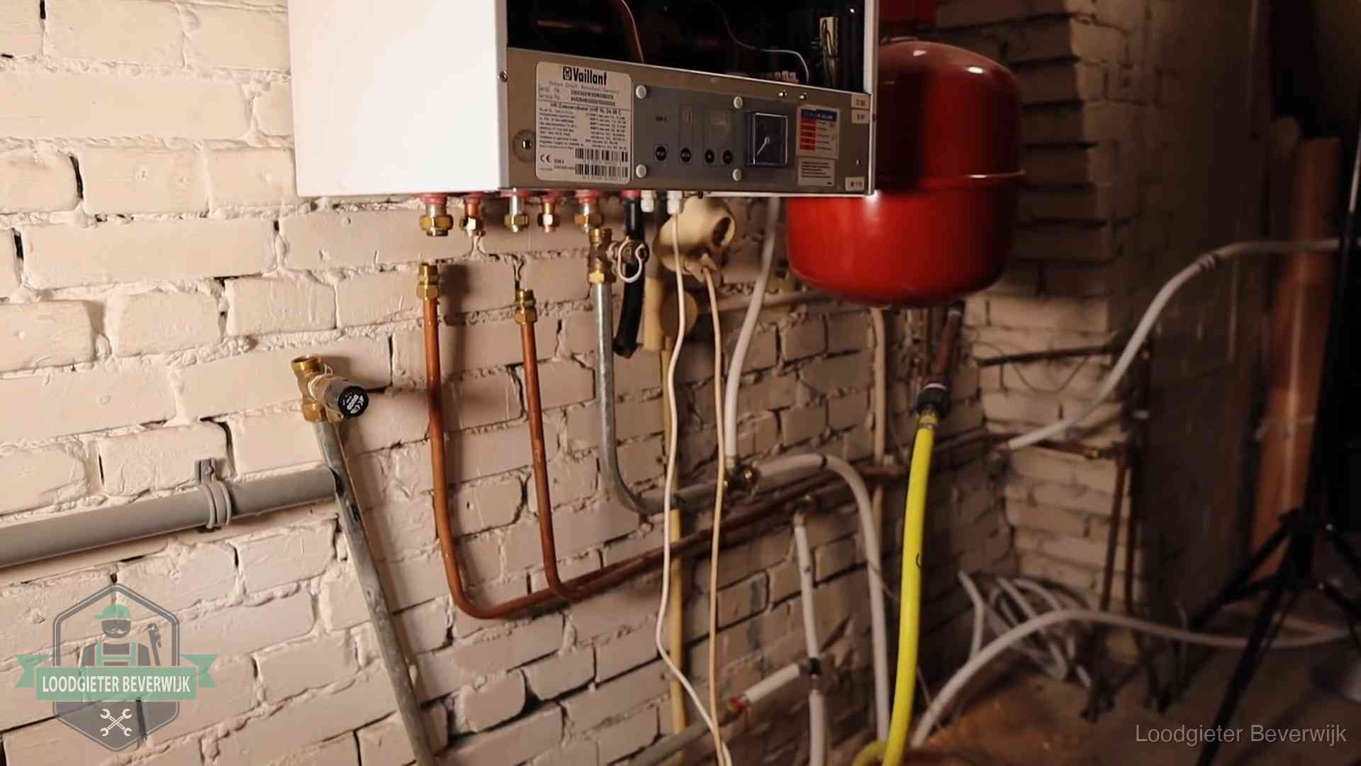 Verouderde cv-ketel met een wirwar van oude leidingen in een woning in Beverwijk