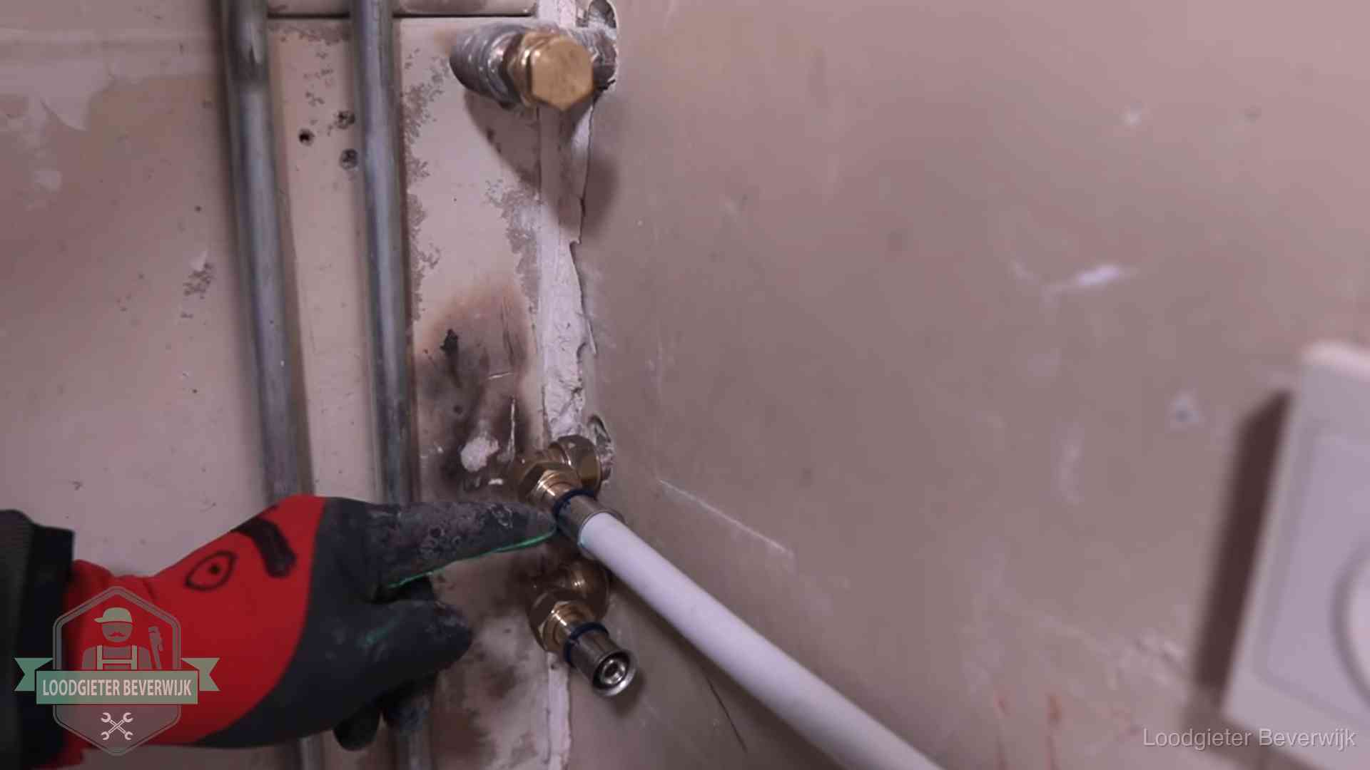 Loodgieter wijst de persfitting op nieuwe muuraansluitingen aan in een woning in Beverwijk