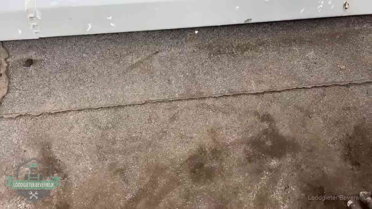 Stormschade en neerslag op daken in Beverwijk Vochtplekken bij de naad van een plat dak na aanhoudende regen in Beverwijk