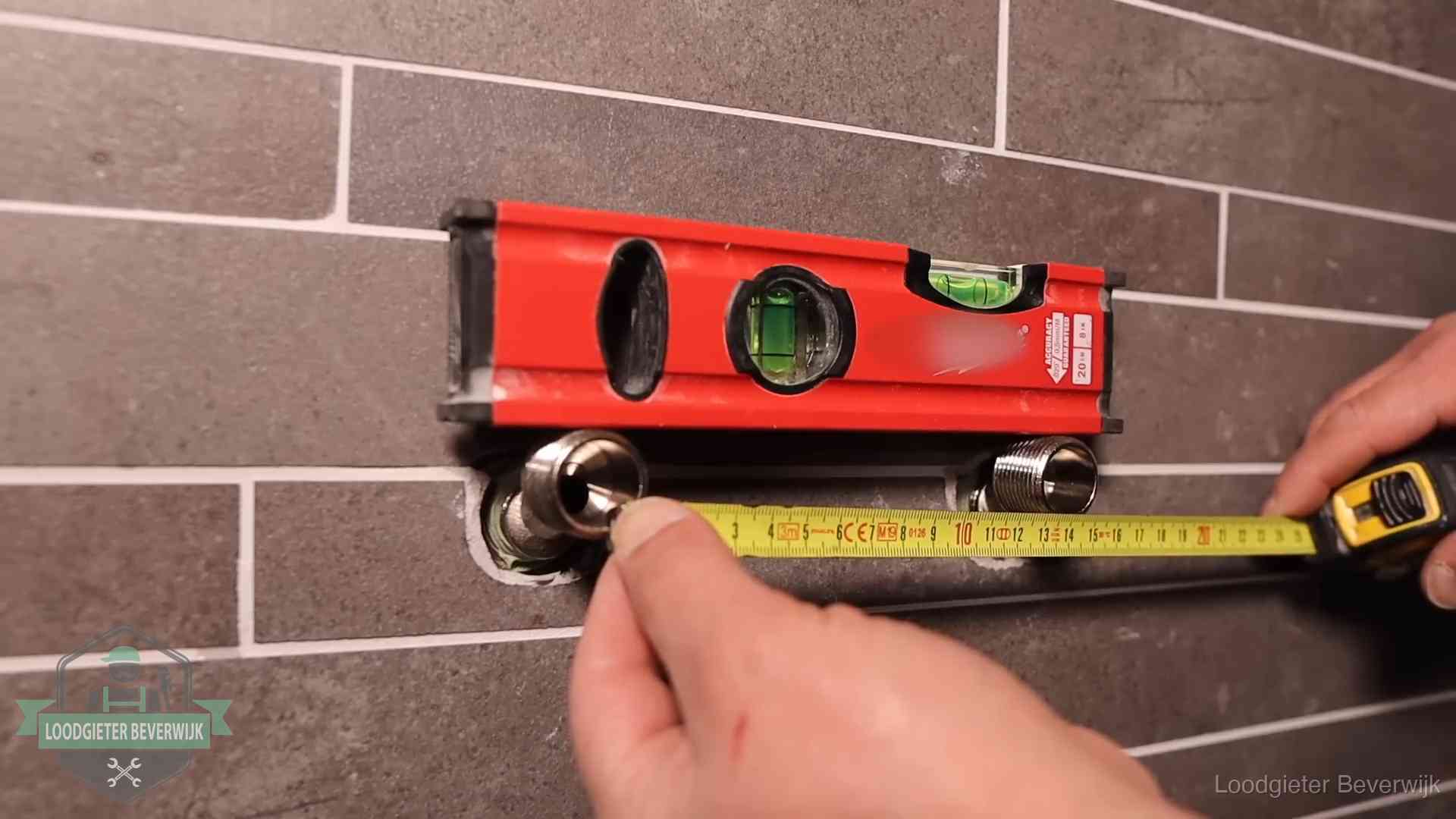 Waterpas en duimstok bij kraan-aansluitpunten in een badkamer in Beverwijk