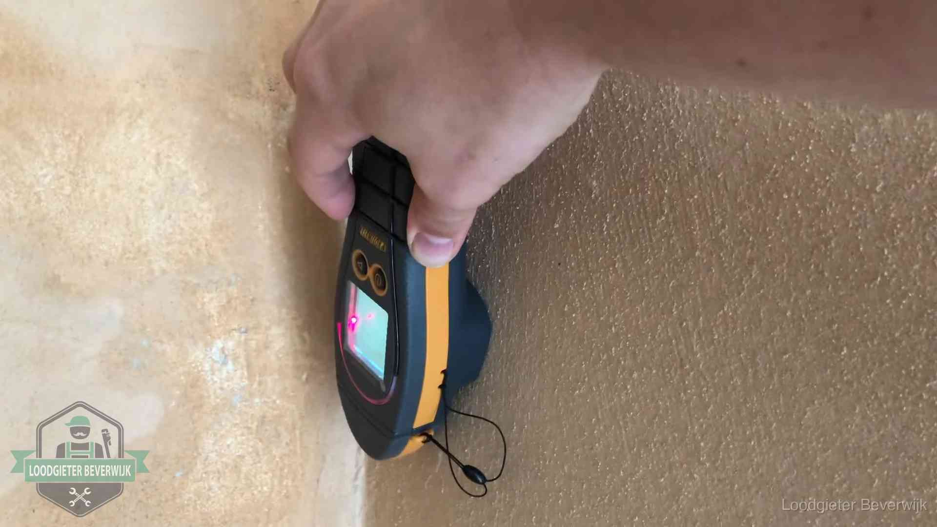 Daklekkage opsporen zonder hakwerk in Beverwijk Vochtmeter tegen een muur met vochtplekken tijdens het opsporen van een daklekkage in Beverwijk