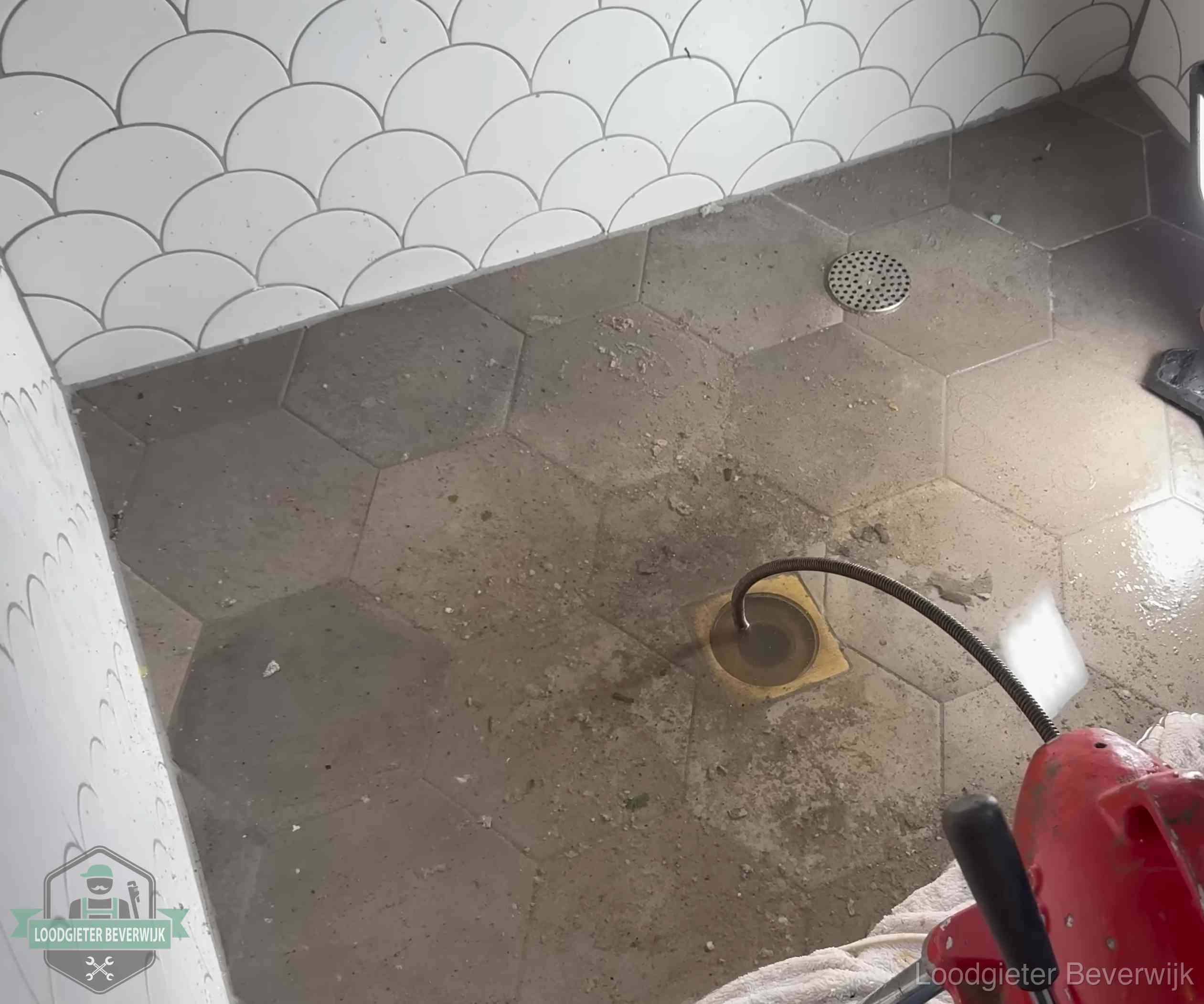 Vloerput met waterslot in een badkamer in Beverwijk, een bron van stank als het waterslot droogstaat