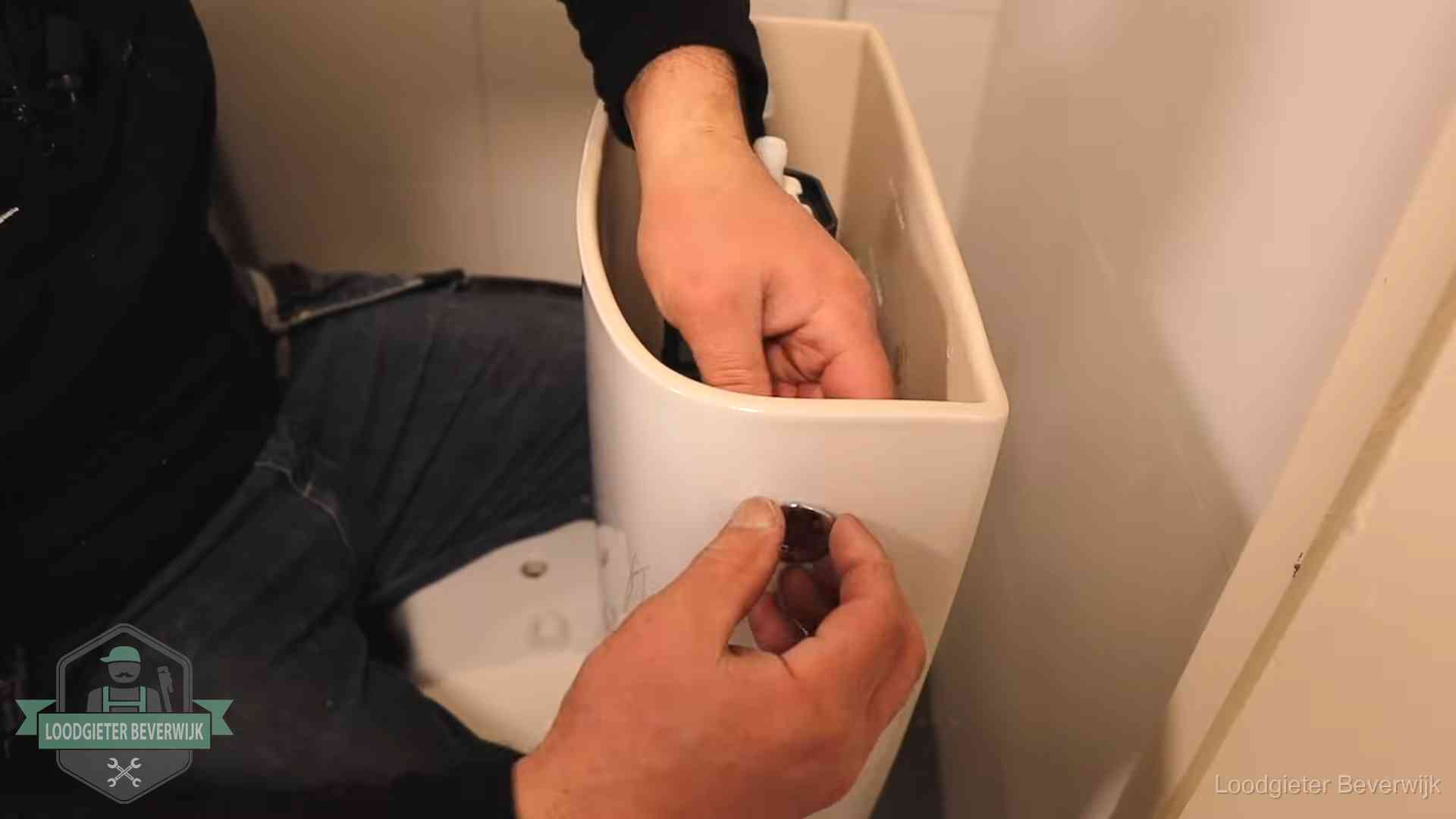Drukknop van een duoblok-stortbak wordt gemonteerd bij een toilet in Beverwijk