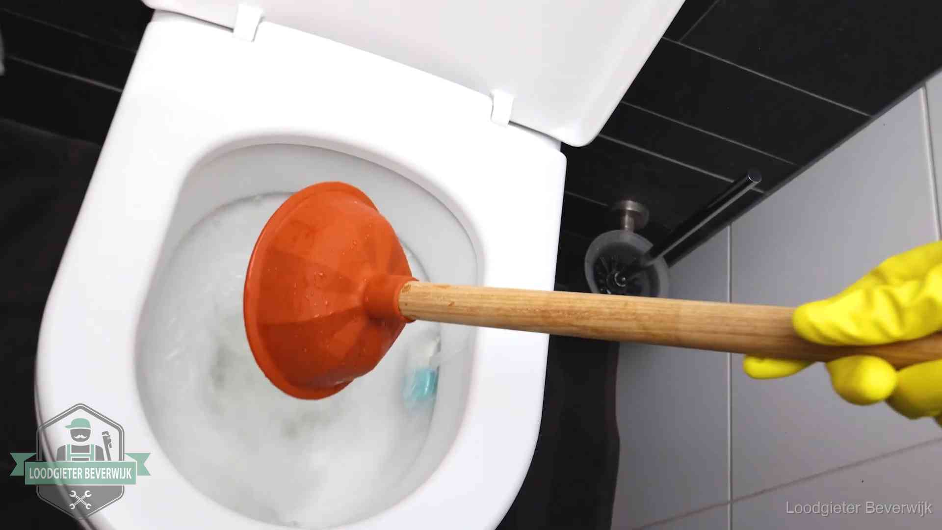 Plopper wordt in de wc-pot gedrukt bij het ontstoppen van een toilet in Beverwijk